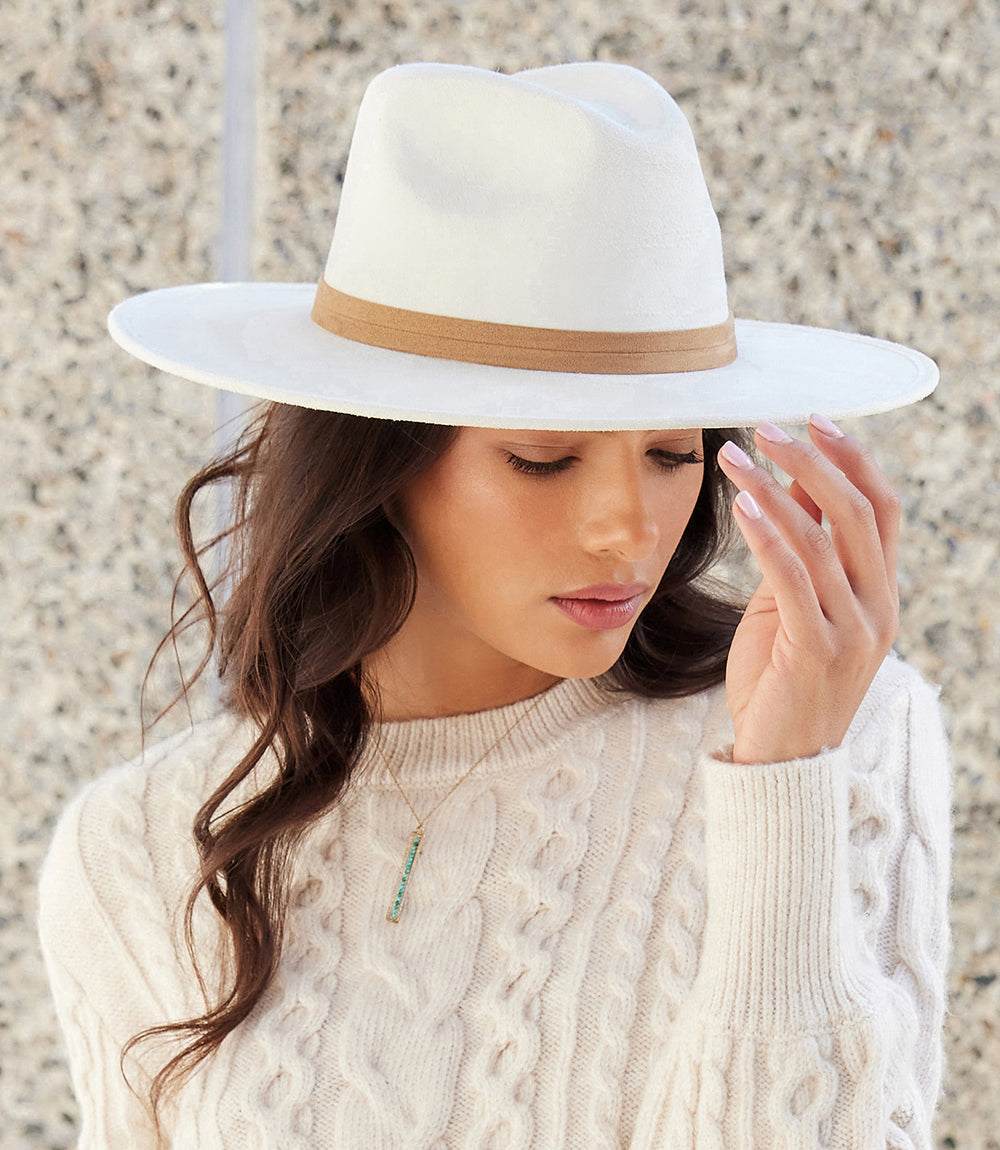 woman wearing white faux suede fedora hat with tan band outdoors