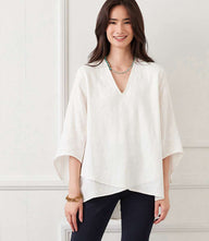 Woman wearing off-white bracelet sleeve embroidered asymmetric top with V-neck and layered hem