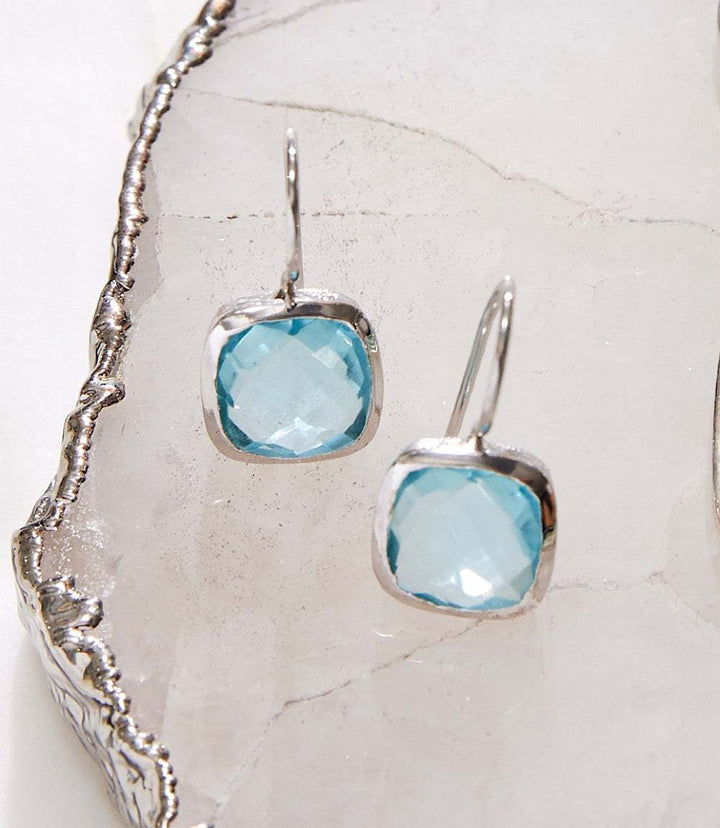 Elegant blue topaz drop earrings with cushion cut stones set in rhodium-plated brass
