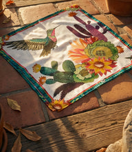 Cactus Blooms silk scarf with vibrant hummingbird and cactus design in bright pinks, turquoise, lime, golds, and blues on smooth satin silk
