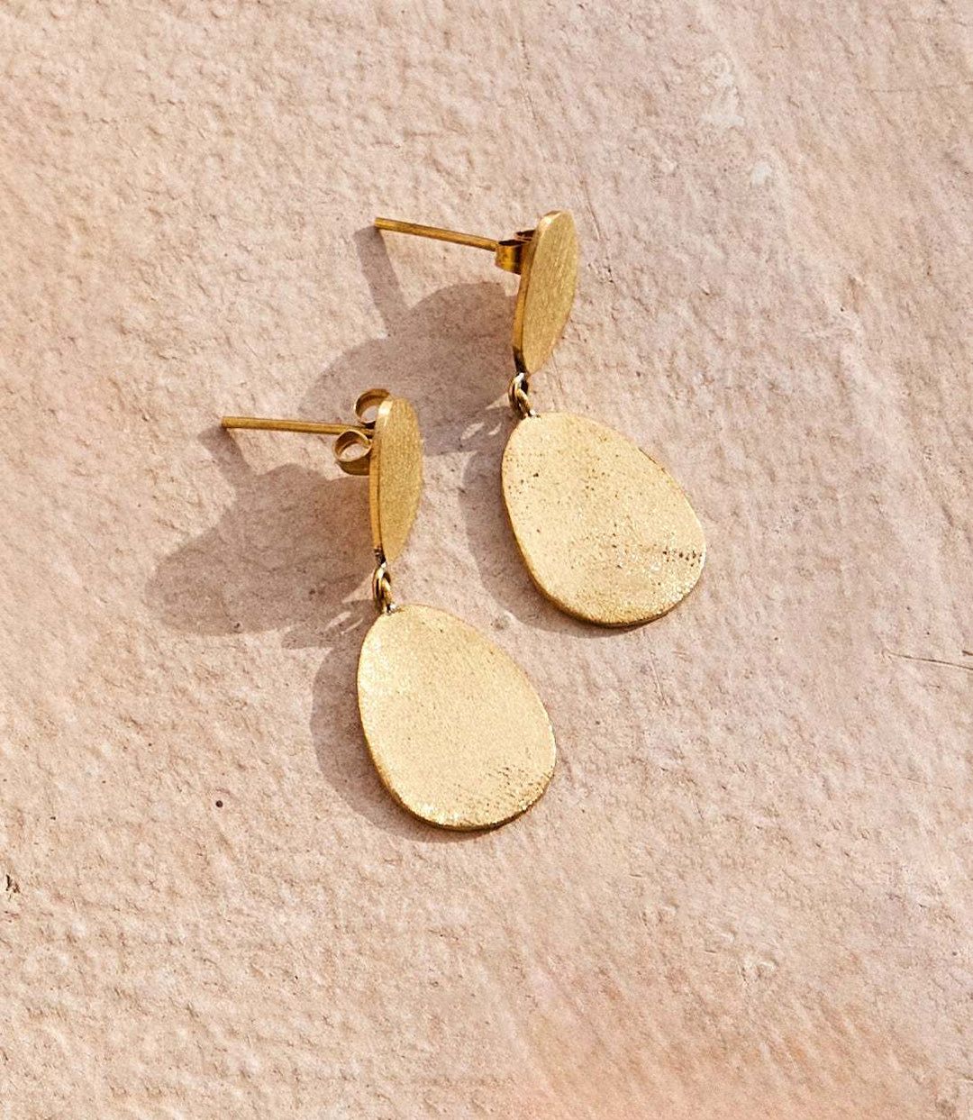 Gold two drop earrings with brushed textured organic-shaped solid brass design handcrafted in Kenya