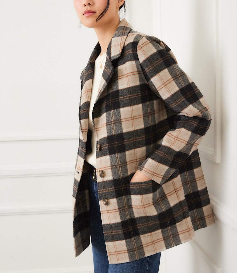 Woman wearing oversized brushed plaid blazer with beige, black, and brown pattern and front pockets