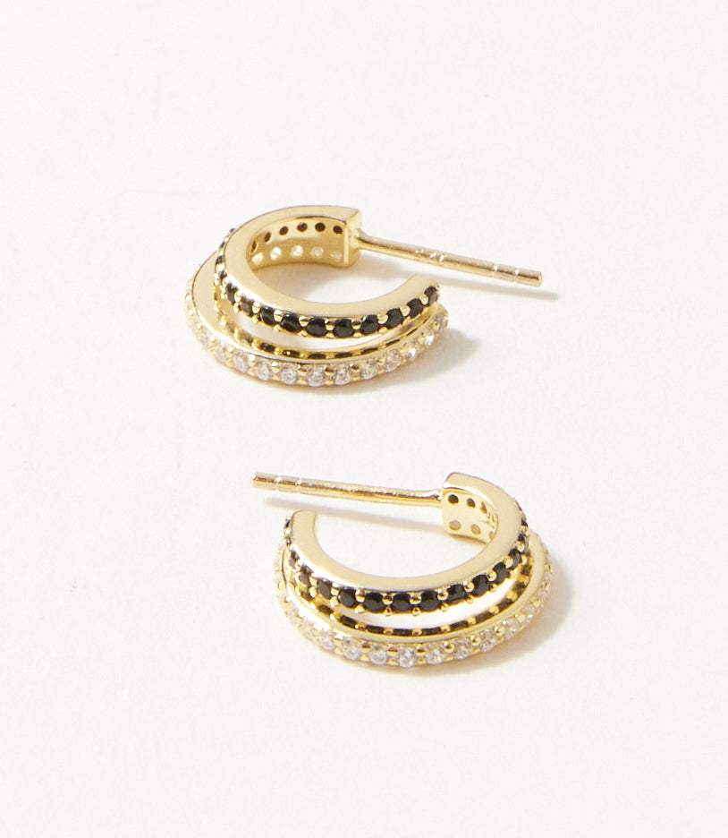 Gold vermeil Twin Huggie Earrings with overlapping double hoops lined with black and clear cubic zirconia studs
