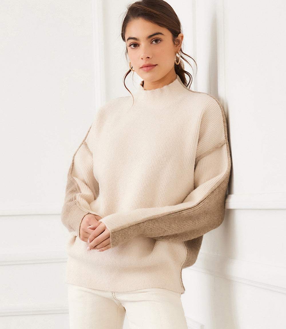 Woman wearing beige colorblock mock neck sweater with relaxed fit and drop shoulder sleeves