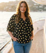 Plus size puff sleeve peasant top with black and yellow floral print, front button closure, and raglan sleeves