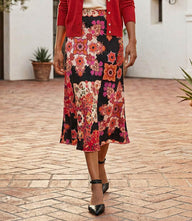 Bias cut midi skirt with red and magenta floral print on black background and elastic waist