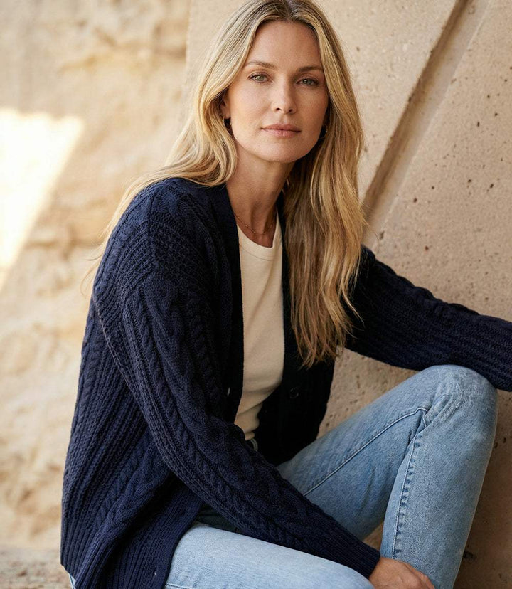 Woman wearing cozy cable knit cardigan sweater with V-neck and front buttons