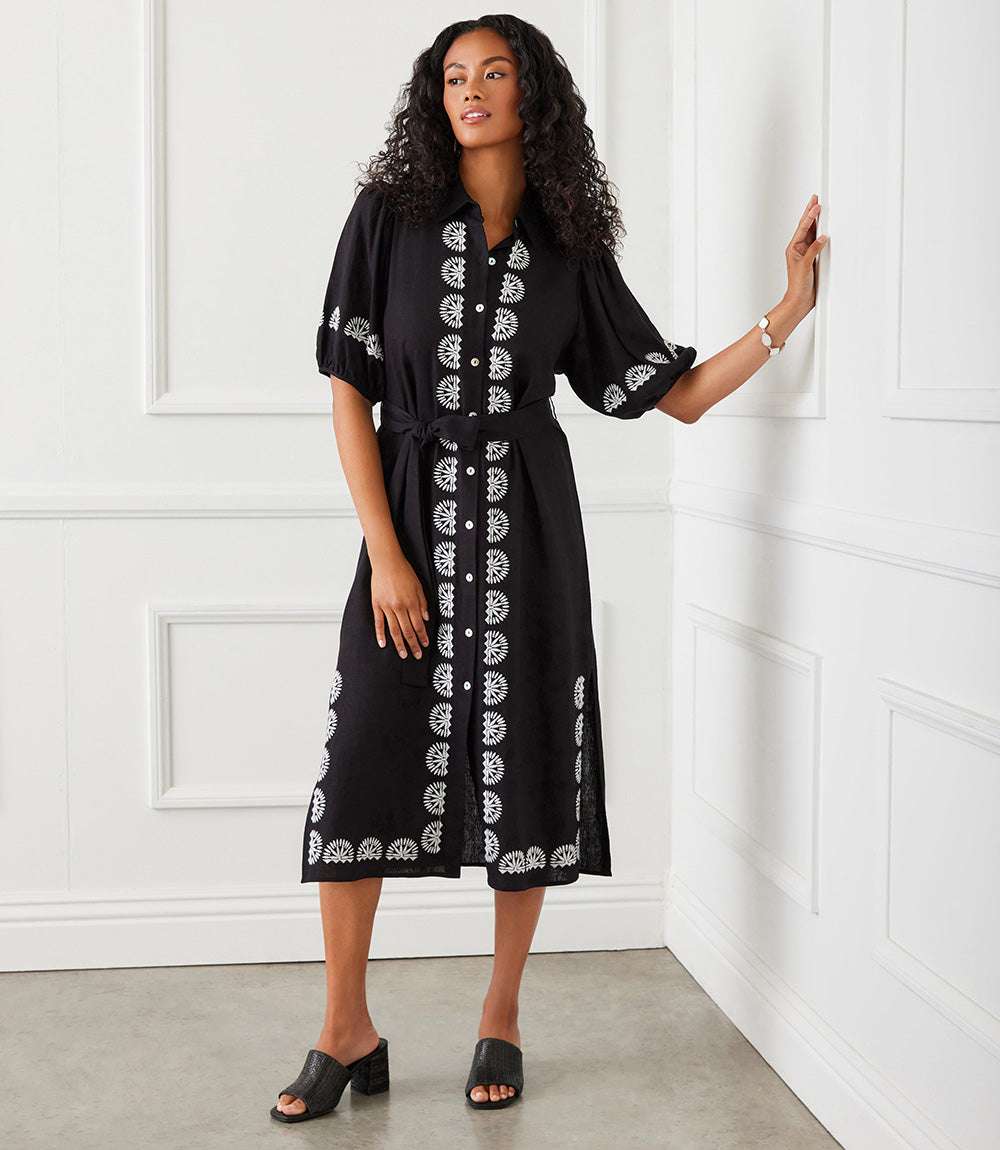 Black puff sleeve embroidered shirtdress with removable waist tie and midi length worn by woman