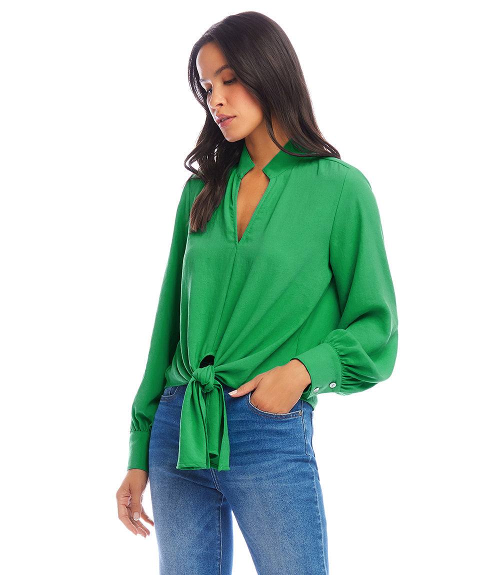 Woman wearing green long sleeve tie-front top paired with blue jeans
