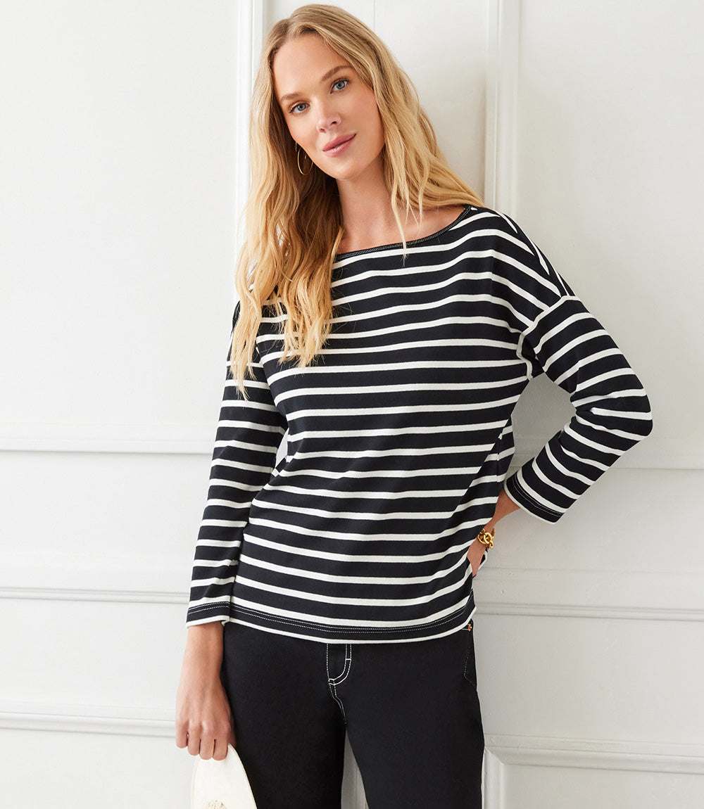 Woman wearing black and white Stripe 3/4 Sleeve Boatneck Top with relaxed fit and drop shoulder sleeves.