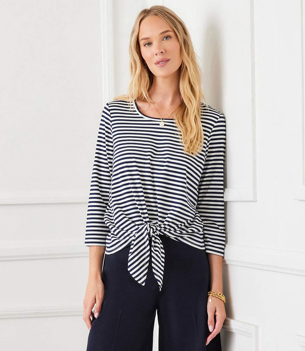 Woman wearing a navy and white striped 3/4 sleeve tie front top with crew neck and set-in sleeves.