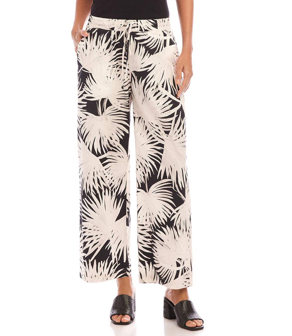 Women's drawstring cropped pants with wide-leg silhouette and tropical palm print in cream and black, made from soft breathable cotton.