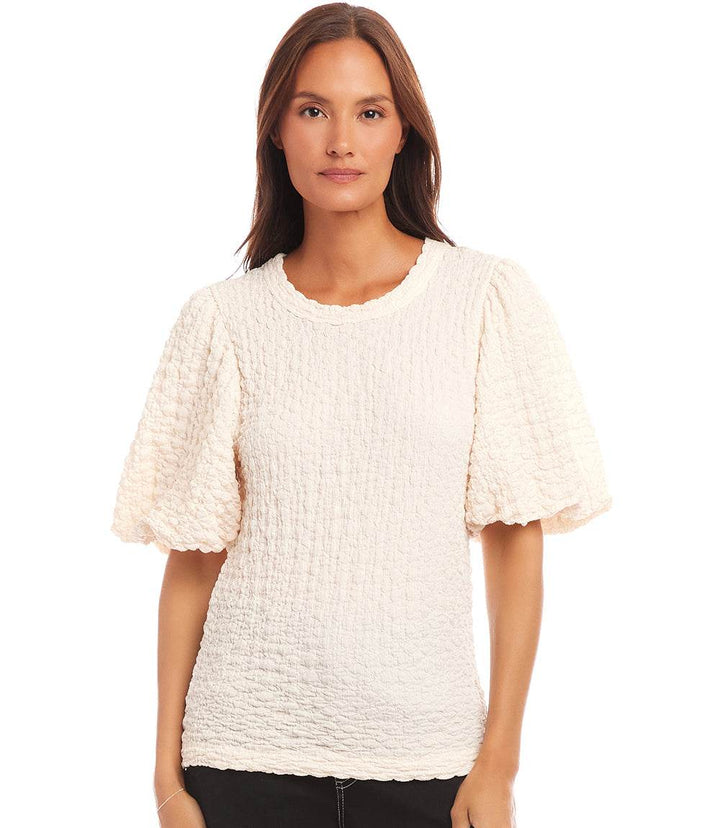 Woman wearing white puff sleeve textured top with bubble knit design and crew neck