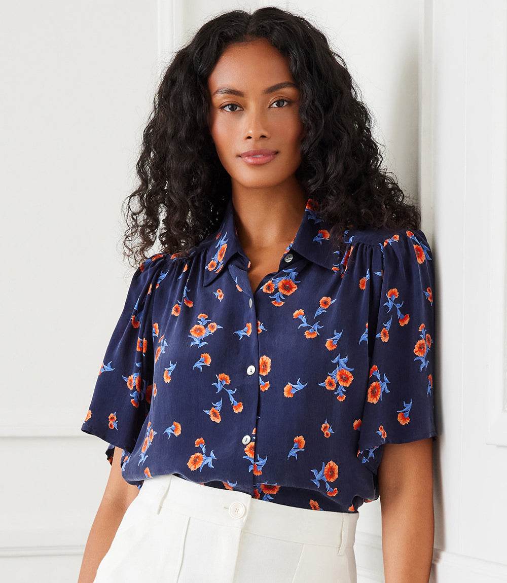 Navy shirred button up blouse with orange carnation print and puff sleeves on model