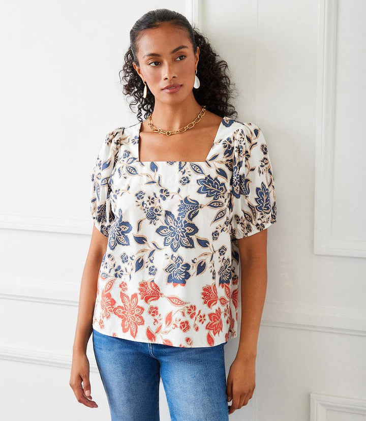 Woman wearing a lightweight cotton puff sleeve square neck top with batik border poplin print paired with high waist jeans