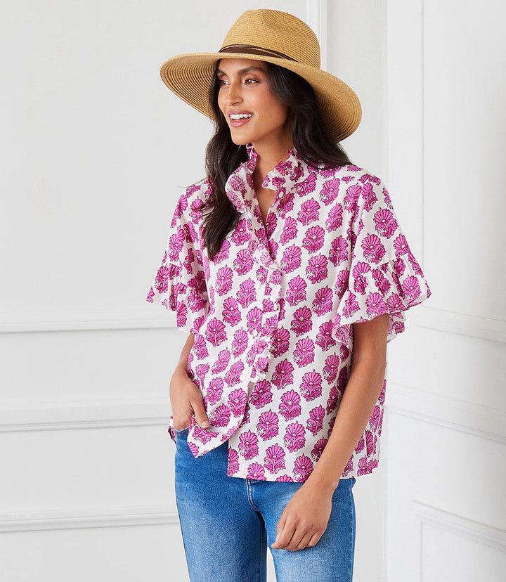 Woman wearing short sleeve ruffle trim top with pink batik flower pattern and mandarin collar