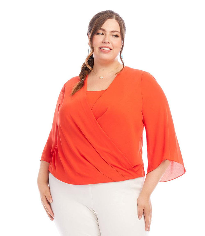 Plus size drape front crossover top in bright orange with flutter sleeves and pleated hem detail