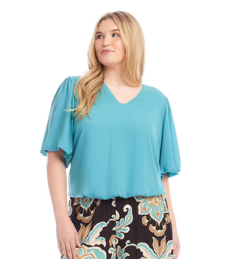 Plus size puff sleeve top in silky crepe with V-neck and elasticized hem, styled with patterned pants