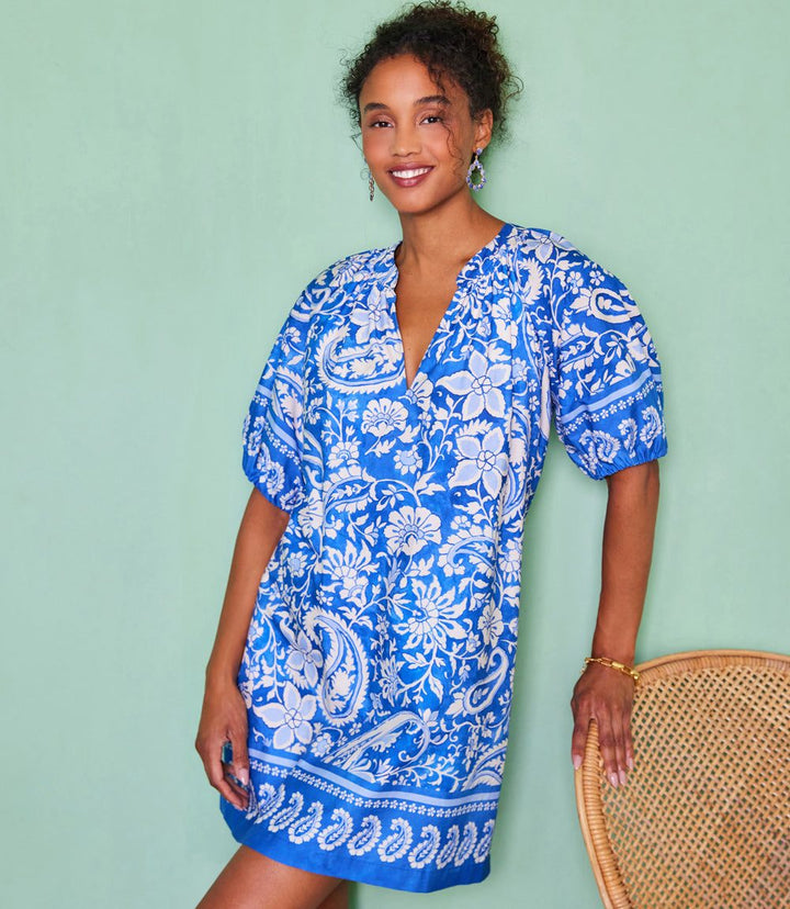 Woman wearing blue Puff Sleeve Peasant Dress with paisley border cotton print and puff sleeves.