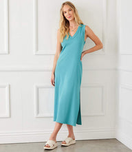 Woman wearing sleeveless ribbed V-neck midi column dress with side slit in blue cotton knit