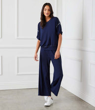 Off white drawstring lounge pants with contrast stitching and wide leg in heavy French terry fabric