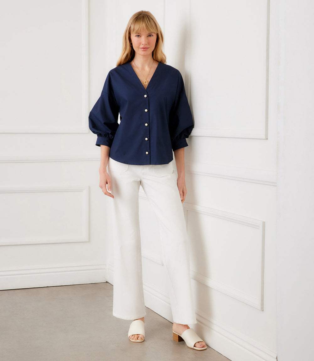 White cotton poplin lantern sleeve top with pearl button front and V-neckline