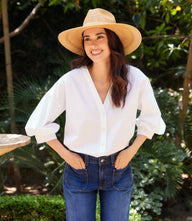 White cotton lantern sleeve pearl button top with V-neck and gathered cuffs