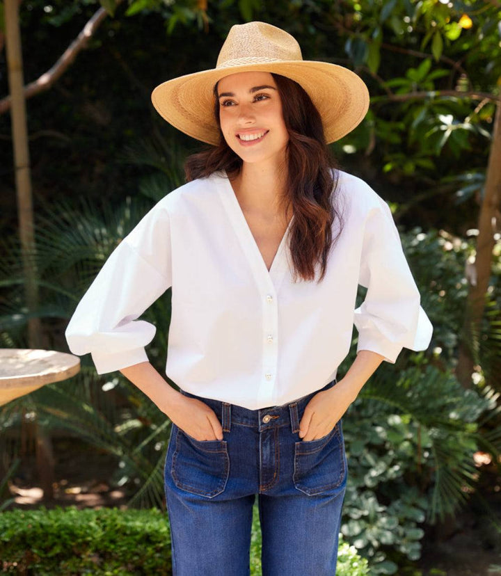 White cotton lantern sleeve pearl button top with V-neck and gathered cuffs