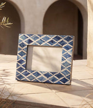 Handcrafted mosaic bone picture frame with unique dyed bone pieces set in resin, holding 4x6 photos.