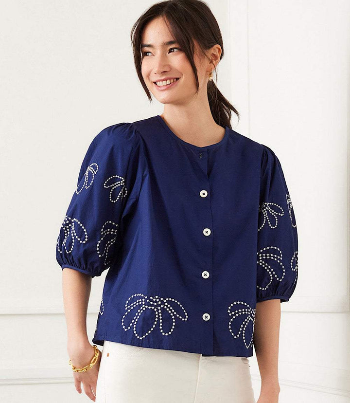 Navy blue embroidered puff sleeve shirt with white floral designs and front buttons