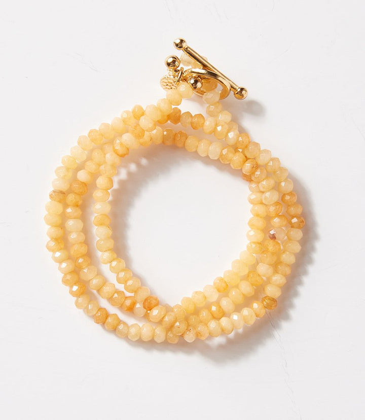 Beaded gemstone toggle bracelet with yellow crystal beads and gold toggle clasp, designed to wrap wrist three times or wear as a necklace