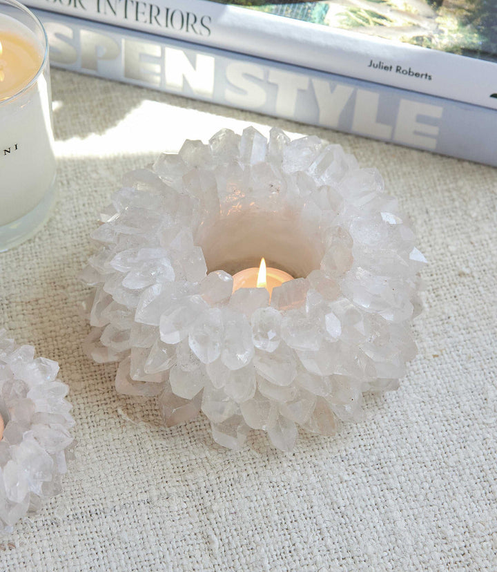 Crystal candleholder with natural quartz crystals holding lit votive candle