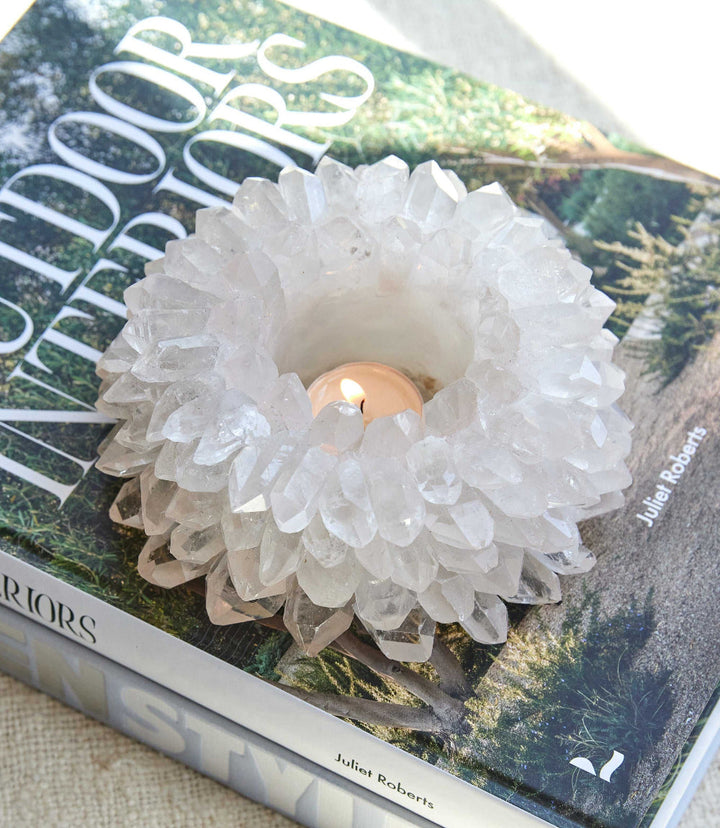 Large Crystal Candleholder with intricate crystal design holding a lit candle on a book titled Outdoor Interiors