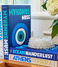 Mykonos Muse book cover featuring whitewashed buildings and windmills on Mykonos island