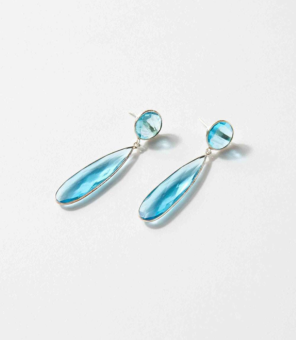 Long teardrop blue topaz gemstone earrings with silver plating, elegant and versatile design.
