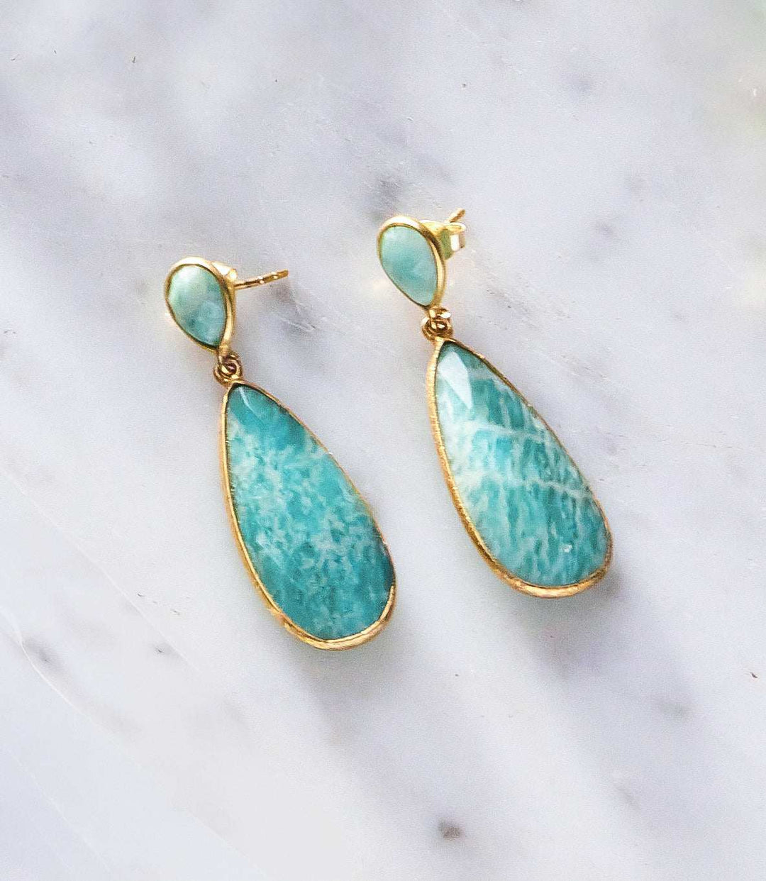 Double Teardrop Earrings with gold plated 925 silver and amazonite stones on marble background