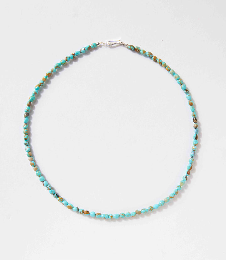 Turquoise beaded necklace with sterling silver clasp handcrafted by Navajo artists, 18 inches long, unique natural stones.