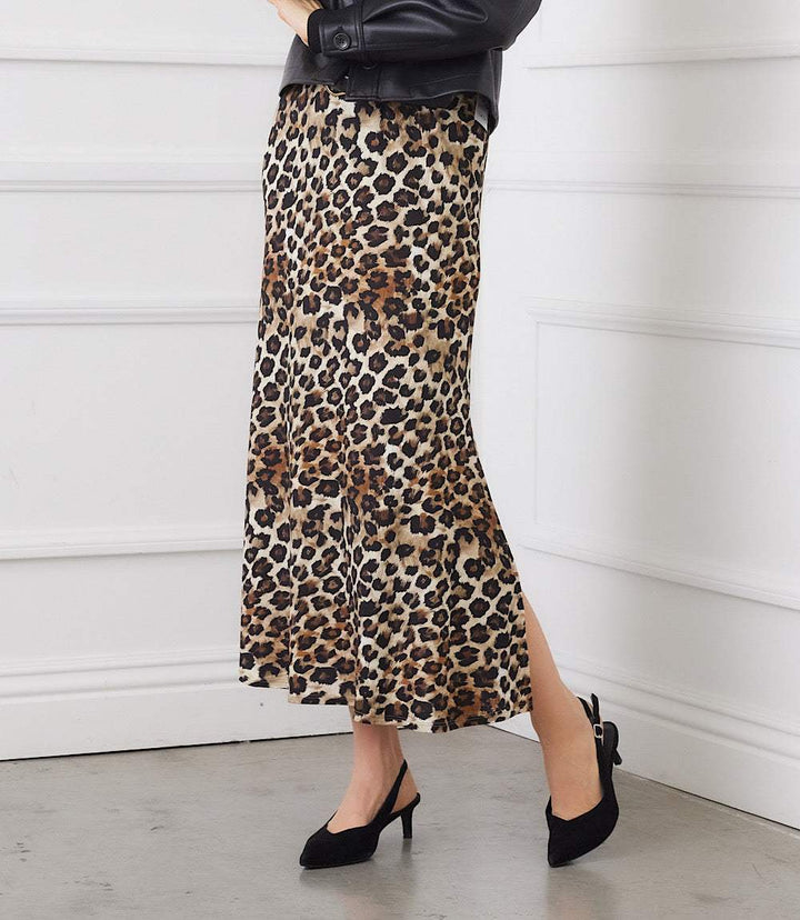 Woman wearing a leopard print side-slit midi skirt with a pull-on elastic waistband and black heels.