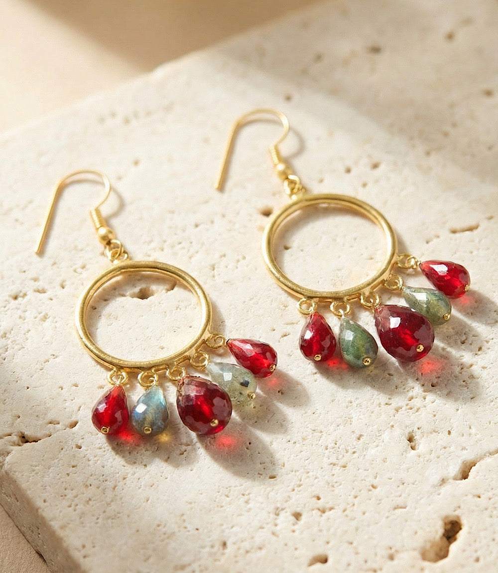 Dangling gemstone hoop earrings with burgundy and gray teardrop gems on gold-tone hoops