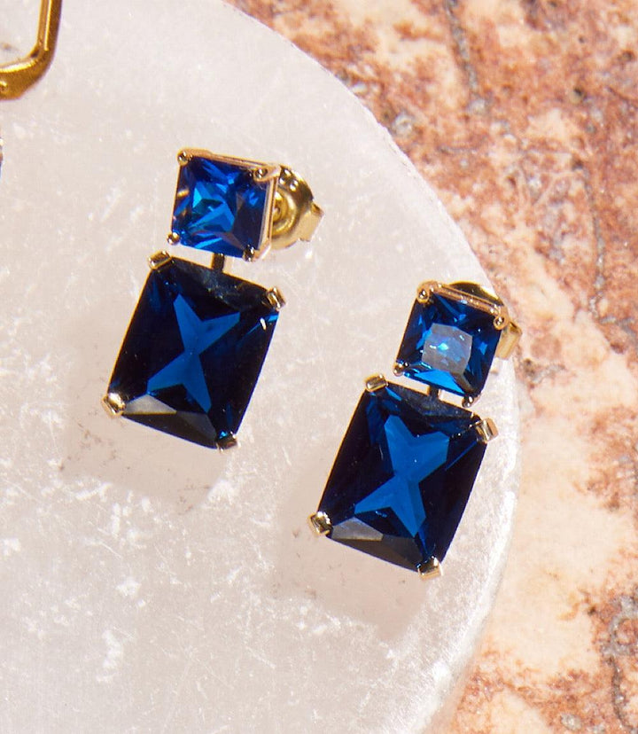 Gold over brass princess cut drop earrings with stacked sapphire blue cubic zirconia stones