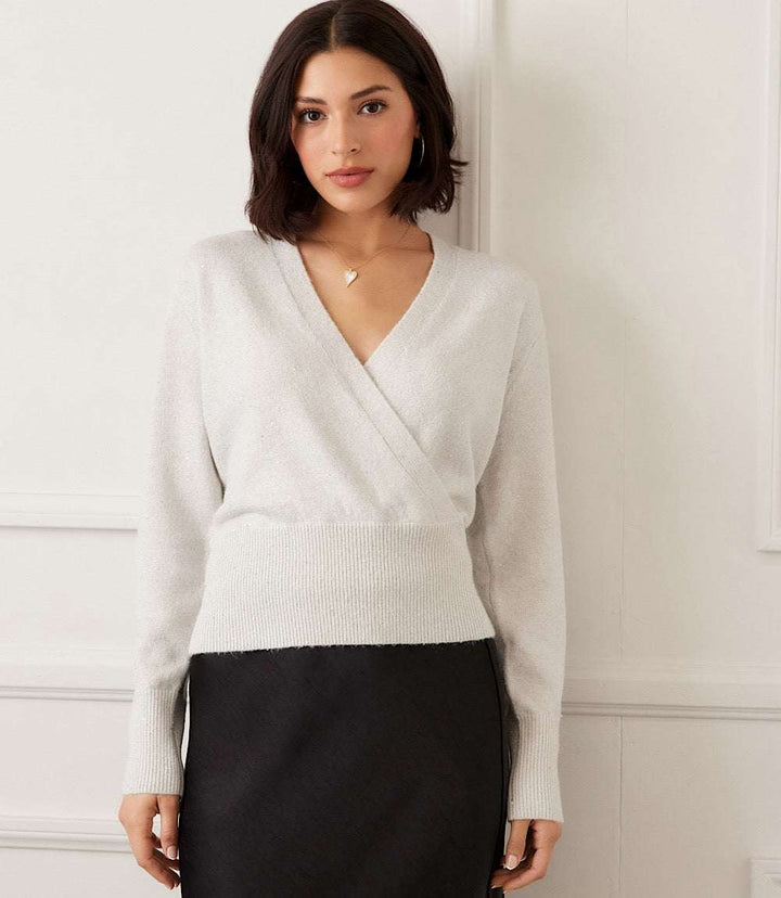 woman wearing white sequin wrap sweater with long sleeves and crossover V-neck