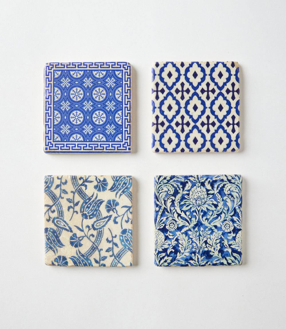 Set of four Mediterranean Tile marble coasters with blue and white intricate patterns and cork backing.