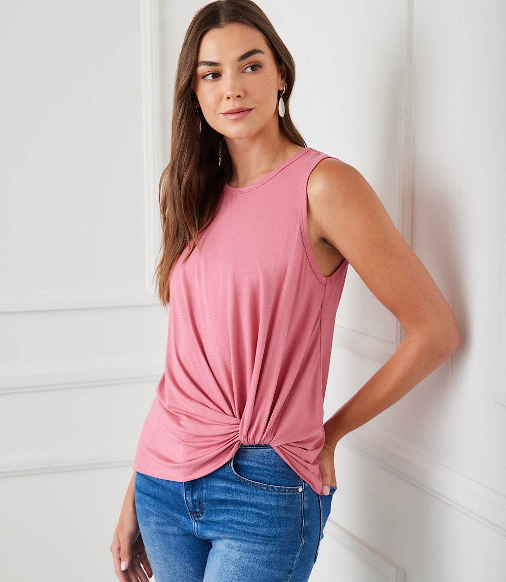 Woman wearing pink sleeveless pick-up top with twist hem and crew neck paired with blue jeans