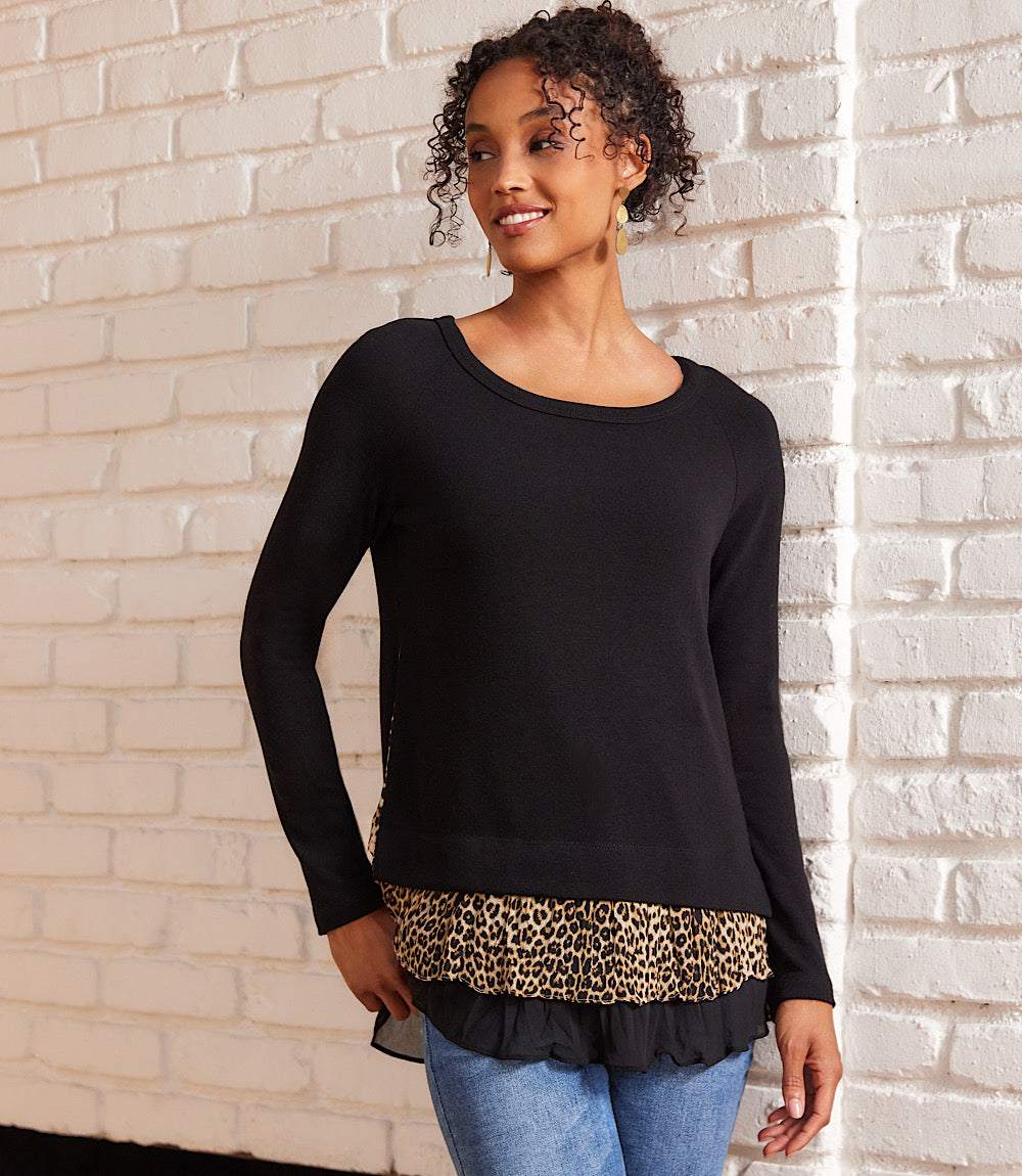 Layered contrast leopard sweater with solid black sleeves and leopard print layered hem on model