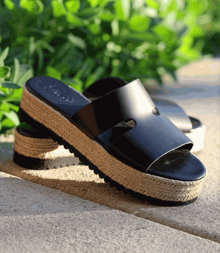 Black leather espadrille slides with woven jute platform heel and round toe, slip-on design