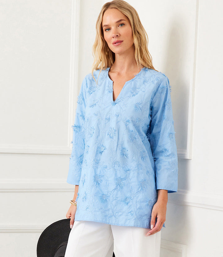 Woman wearing a light blue 3/4 sleeve embroidered tunic with split neck and relaxed fit