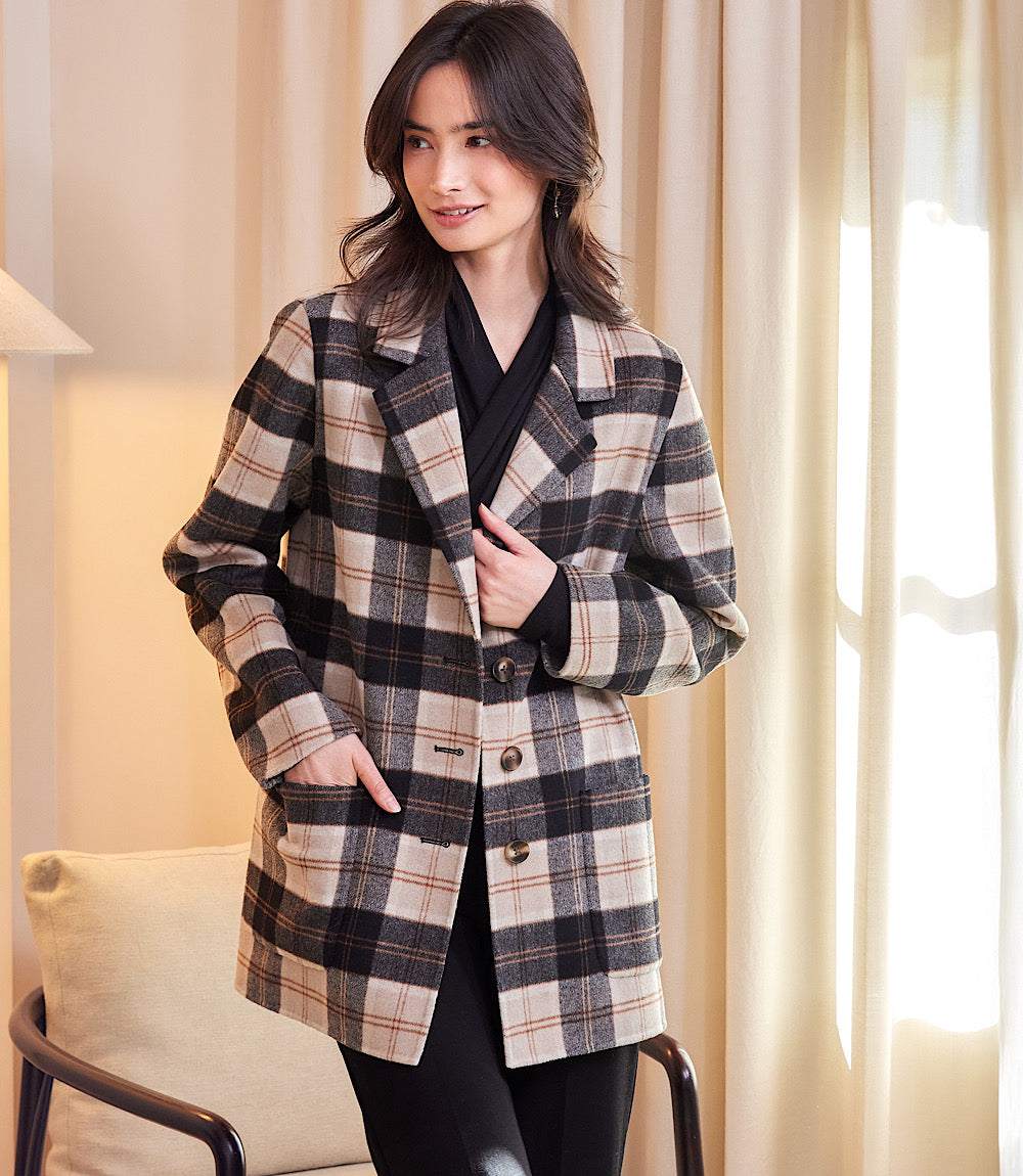 Woman wearing oversized brushed plaid blazer with beige, black, and brown pattern indoors