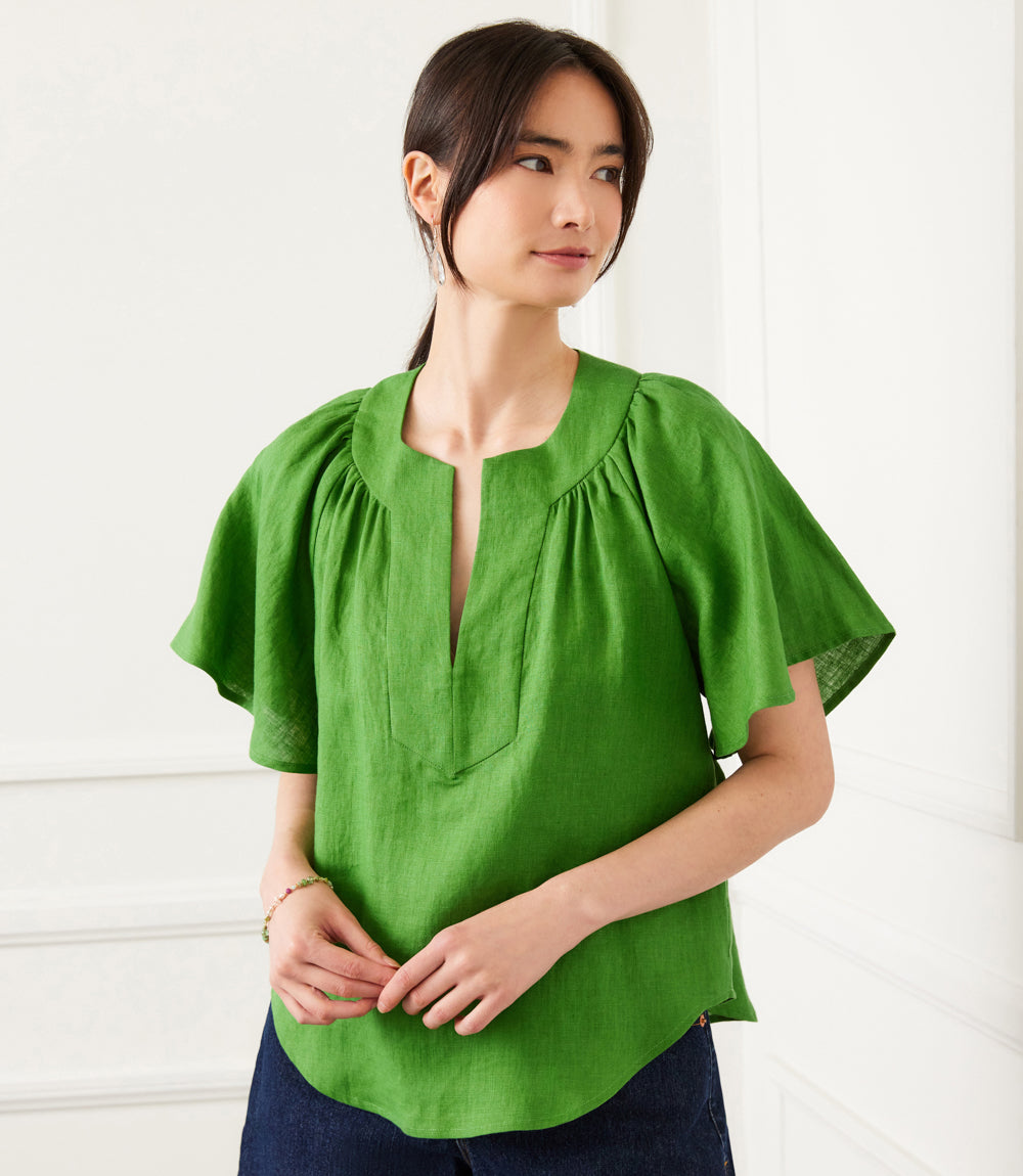 Green linen flutter sleeve top with split neck worn by woman