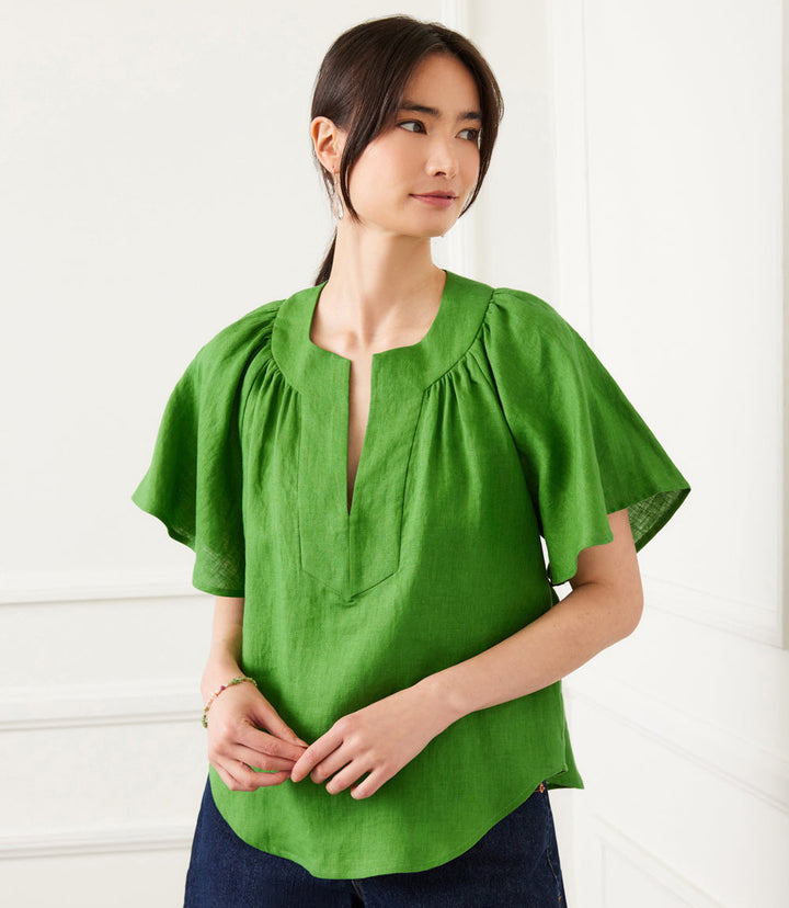 Green linen flutter sleeve top with split neck worn by woman