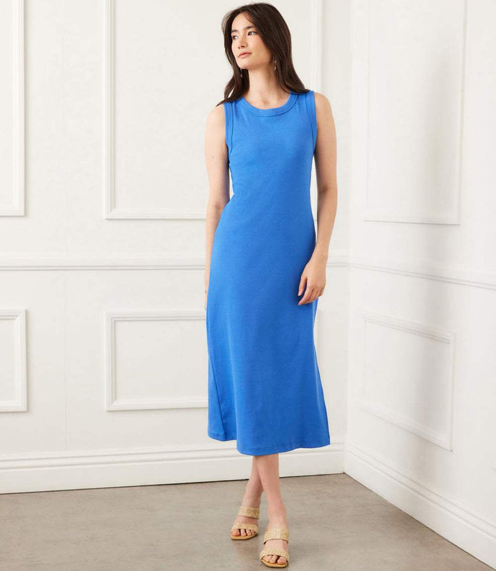 Woman wearing cornflower blue sleeveless ribbed column dress with side slit and crew neck